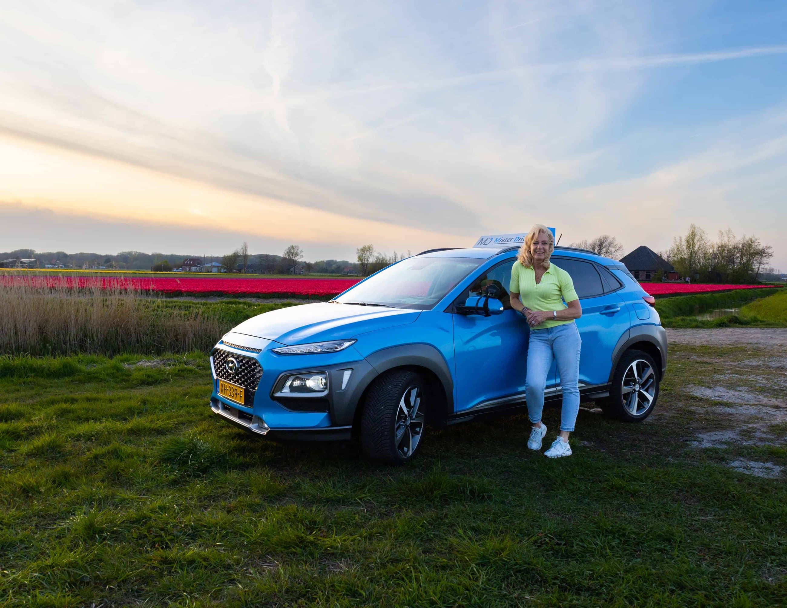 Een instructeur van Mister Drive bij de lesauto in de bollenvelden