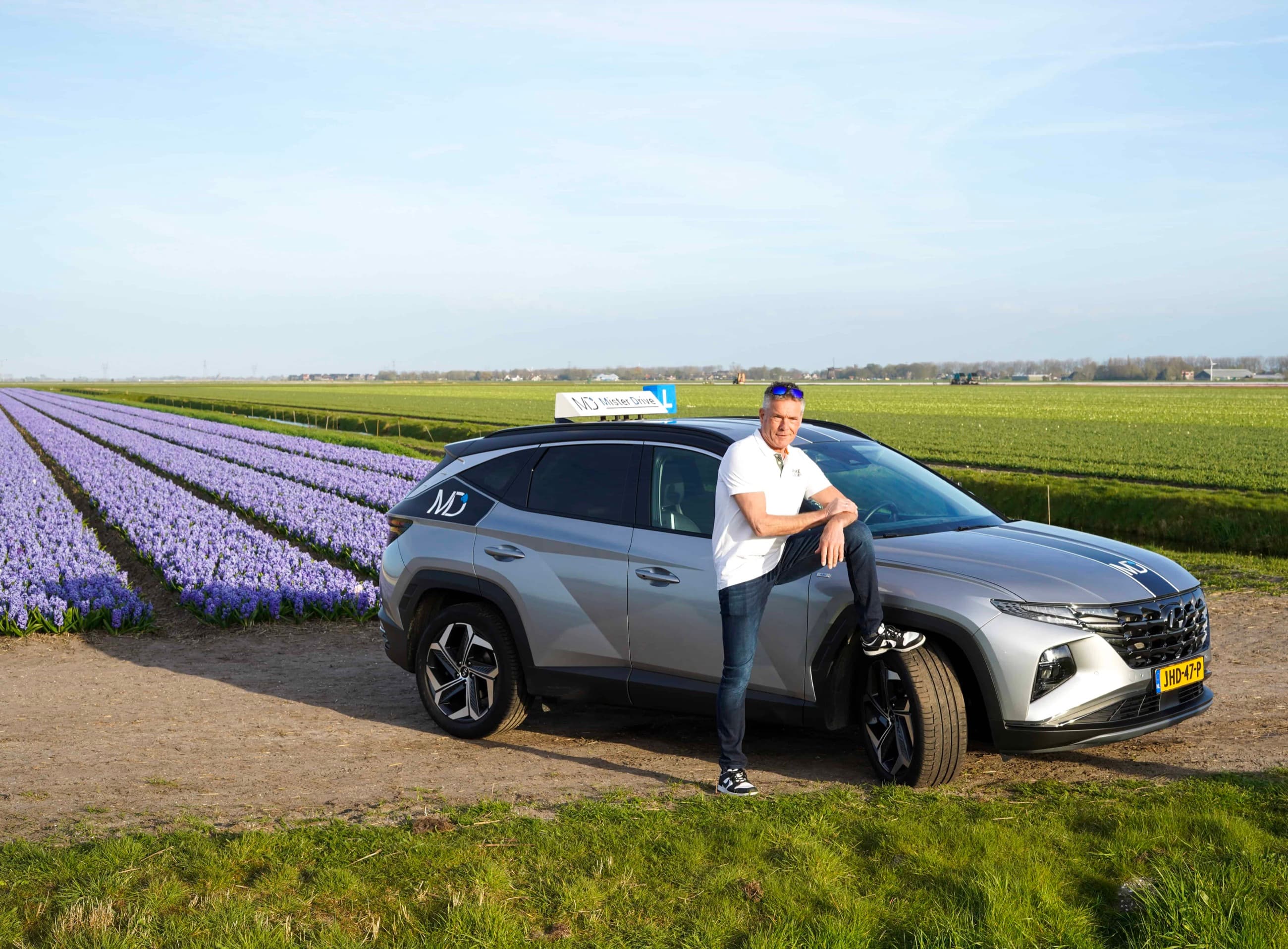 Leon bij een lesauto van Mister Drive in de omgeving van Alkmaar