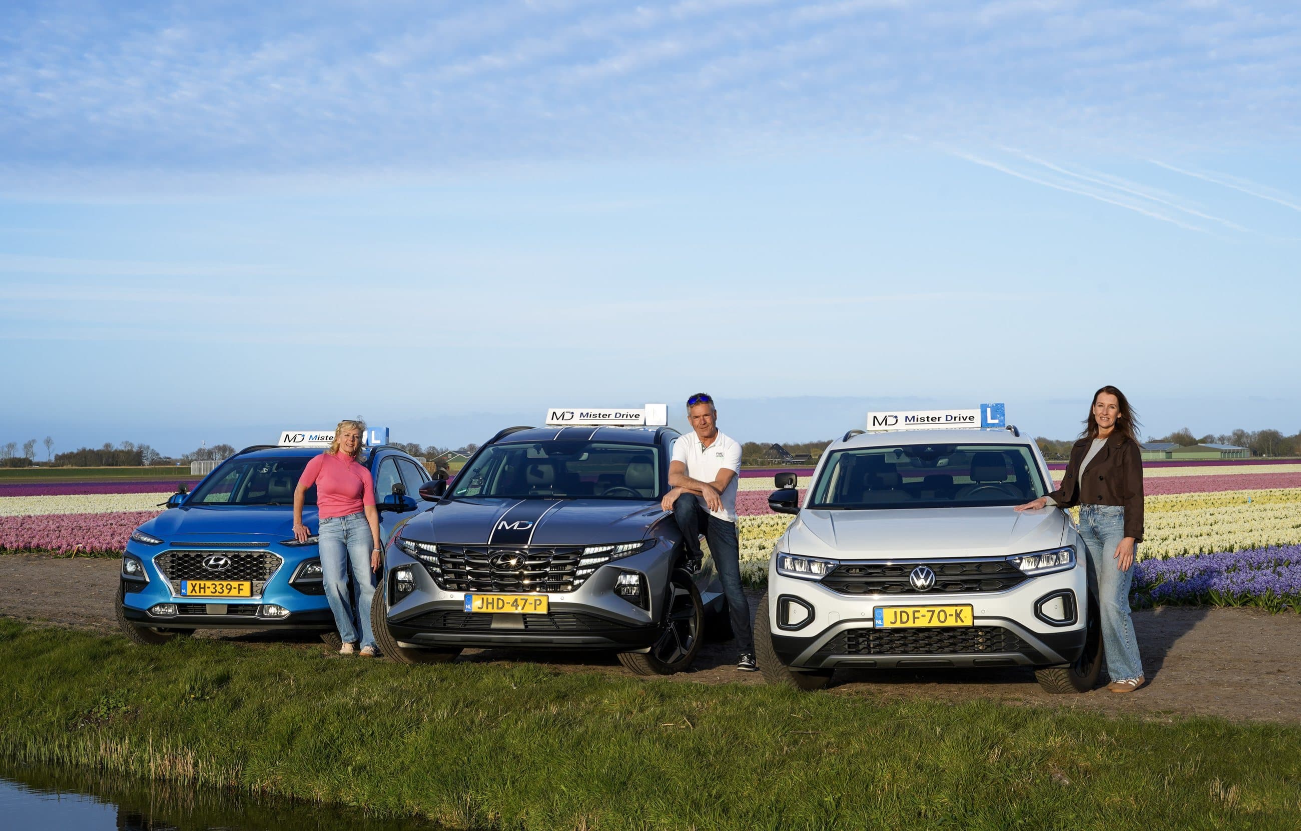 Ellen, Leon en Kim bij de lesauto's in het werkgebied
